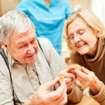 Senioren mit Demenz spielen ein Holz Puzzlespiel als Beschäftigung oder Therapie
