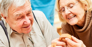 Senioren mit Demenz spielen ein Holz Puzzlespiel als Beschäftigung oder Therapie